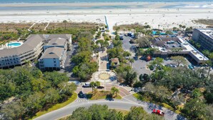 An aerial view of a coastal area with a beach, a parking lot, and buildings. - Sunny Coastal Villa| Private Decks, Pool, Tennis | Near Dining & Scenic Grounds (Hilton Head Island)