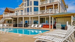 A large, multi-story house with a pool and outdoor seating area. - Premier Oceanfront Dog Friendly w/ Pool, Elevator, Hot Tub, Theater, Game Room (Hatteras)