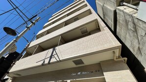 Um edifício de vários andares com fachada em azulejos e uma placa que indica 'Casa Kane'.