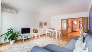 Una sala moderna con sofá, televisión y comedor.