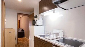 Una cocina compacta con microondas, tostadora y horno integrado.