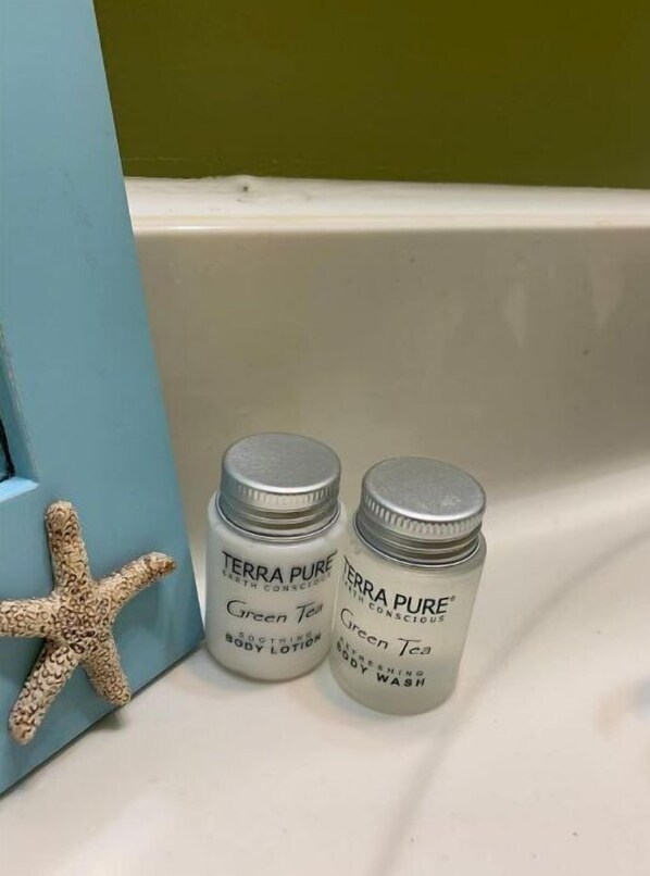 Tina con regadera, toallas, jabón, papel de baño 