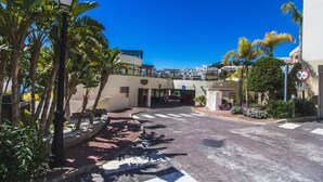 A street view with a building entrance, a pedestrian crossing, and a speed limit sign. - Samara 2 | Marbella Luxury Spa Gym Pools Views (Marbella)