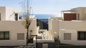 A modern building with a flat roof, white exterior walls, and a view of the sea. - Samara 2 | Marbella Luxury Spa Gym Pools Views (Marbella)