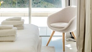 A bedroom with a bed, a chair, and a view of the ocean. - Palo Alto | Marbella Luxury Rooftop Penthouse (Ojén)