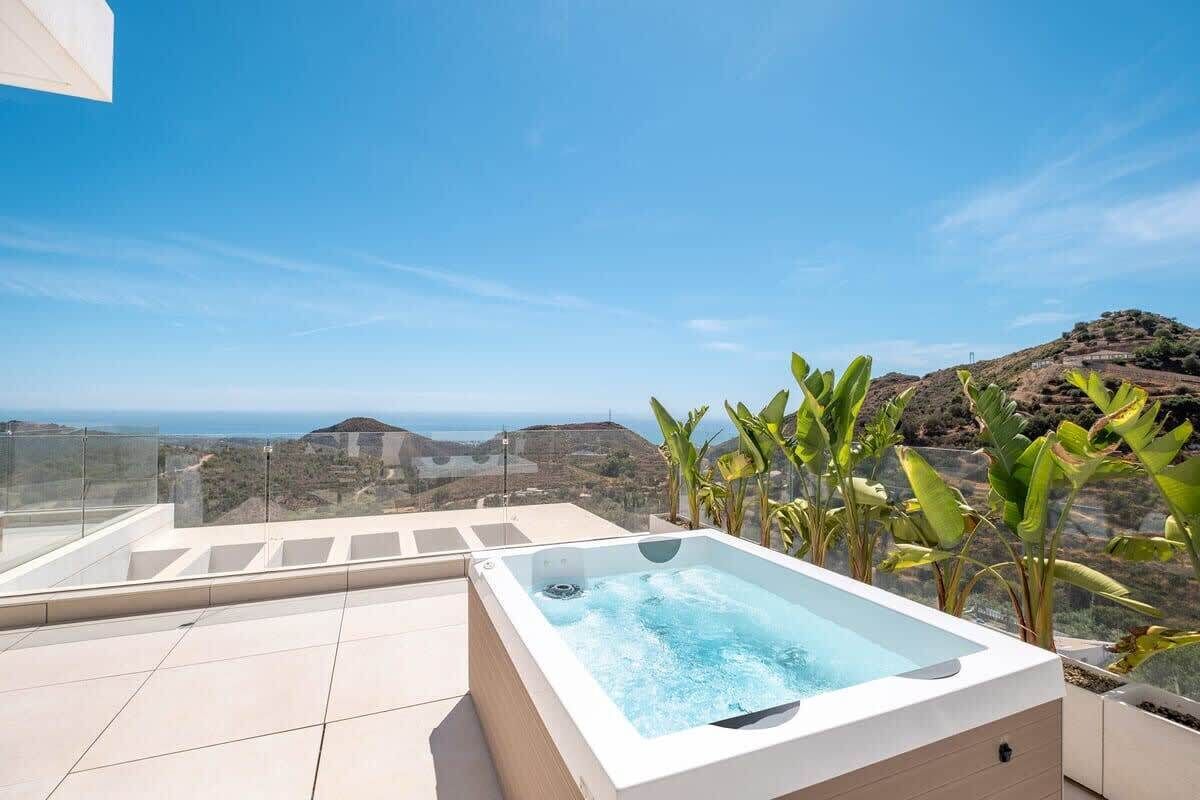 Un bain à remous sur une terrasse sur le toit, offrant une vue sur le paysage et la mer.