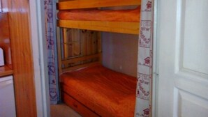 Un lit superposé avec une structure en bois et un lit inférieur.