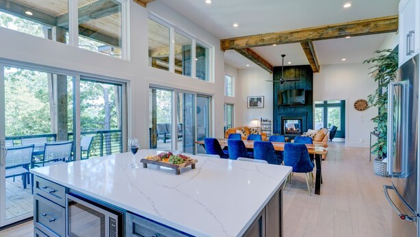 A spacious kitchen with a large island, modern appliances, and a dining area with blue chairs. - New/Modern Rustic/Mins. to Blue Ridge/Spacious/Hot Tub (Mineral Bluff)