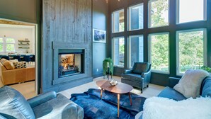A modern living room with a fireplace, large windows, and a cozy seating area. - New/Modern Rustic/Mins. to Blue Ridge/Spacious/Hot Tub (Mineral Bluff)