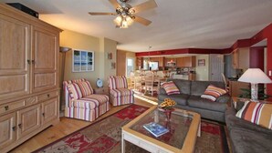 A spacious living room with a ceiling fan, a dining area, and a kitchen. - Oceanfront Condo - Litchfield by the Sea - Community Pool & Hot Tub (Pawleys Island)