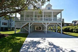 A two-story house with a covered front porch and a staircase leading to the upper level.
