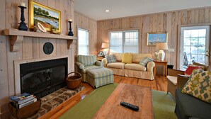 A cozy living room with a fireplace, a sofa, a coffee table, and a television. - Beautiful Ames to Please (Pawleys Island)
