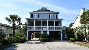 A two-story building with a balcony, a covered entrance, and a staircase leading to the upper level. - Beautiful Ames to Please (Pawleys Island)