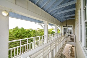A covered porch with white railings, a ceiling fan, and a view of greenery. - Ocean View - North Litchfield Beach - Private Pool (Pawleys Island)