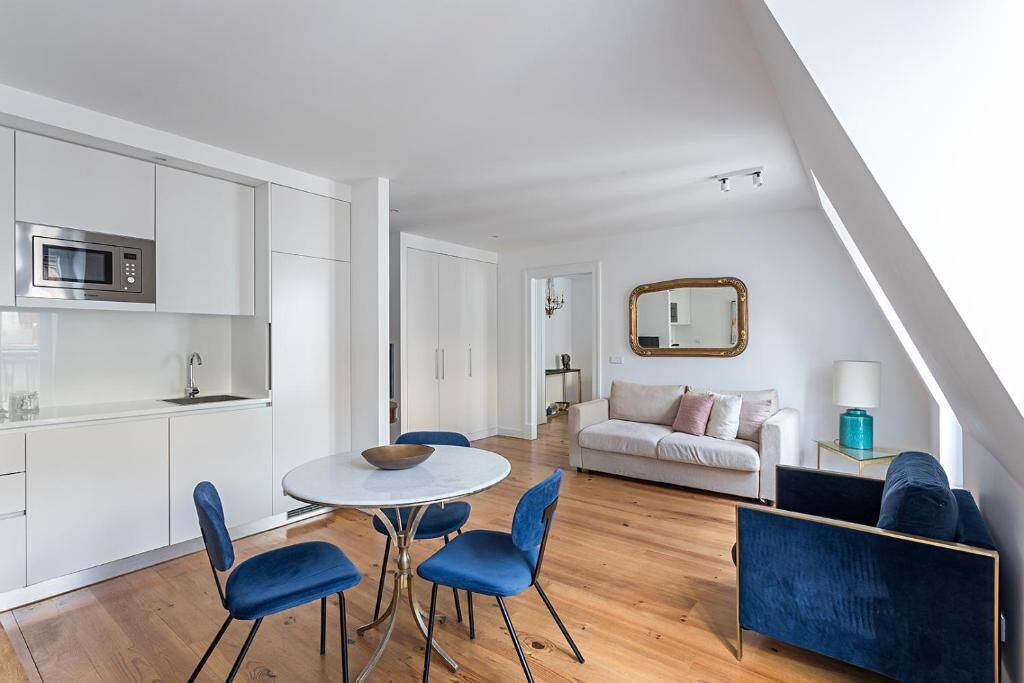 A modern apartment with a kitchen, dining area, and living room.