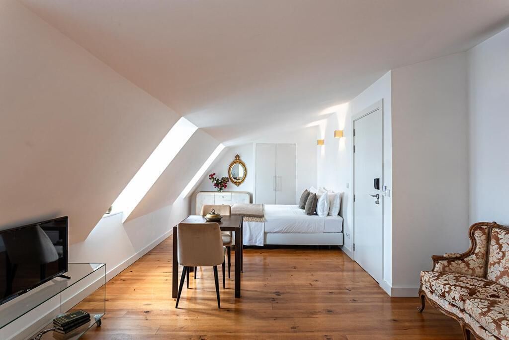 Un appartement moderne de style « loft » comprenant un coin repas, un canapé et un lit.