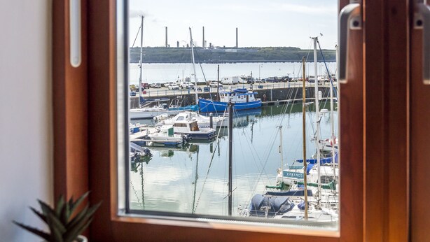 A view from a window of a marina with multiple boats docked.