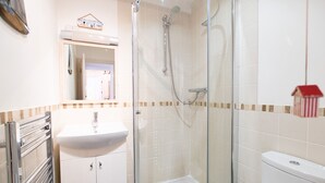 A bathroom with a glass-enclosed shower, a white sink, and a toilet. - Stone’s Throw, Central St Ives – Sleeps 7 – Dog Friendly (St Ives)