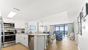 A modern kitchen with built-in appliances, a dining area with a view, and a balcony with a view.