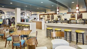 A café with a counter, stools, and tables.