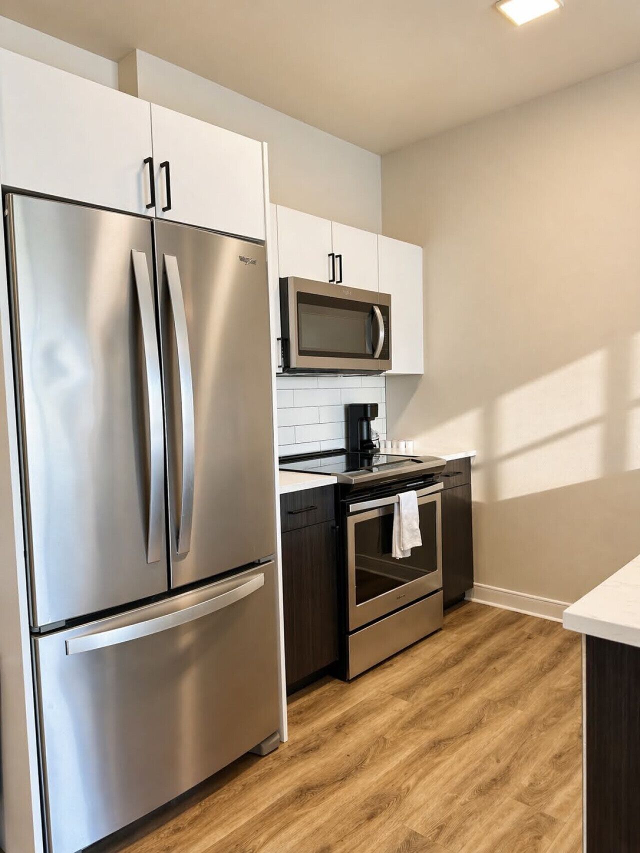 A modern kitchen with stainless steel appliances, a microwave, and a coffee maker.
