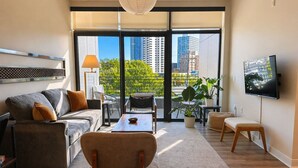 Una sala de estar moderna con un sofá, un sillón, una mesa de centro y un televisor.