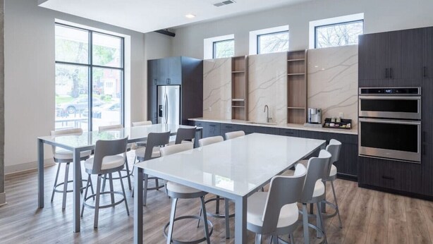 Una cocina moderna con una isla grande, electrodomésticos integrados y mucha luz natural.