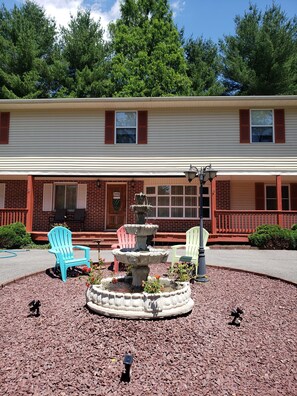 A two-story building with a covered porch, outdoor seating, and a central fountain. - Luxury Lake Front in Gated community with 2 months FREE offer  (Auburn)