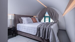 Un dormitorio con cama, mesitas de noche y ventana con cortinas.