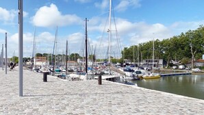 A marina with boats docked along a stone-paved walkway. - Your modern retreat in the heart of Rochefort - A unique experience (Rochefort)