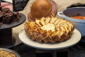 Une miche de pain sur une assiette, avec un décor rustique en arrière-plan.