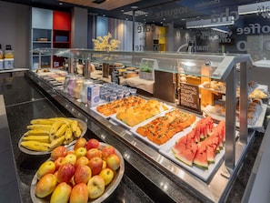 Ein reichhaltiges Buffet mit Früchten, Joghurts und Gebäck.
