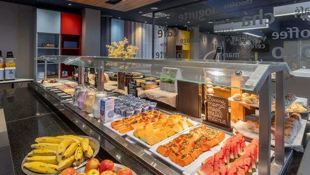 Un bufé con diversas frutas, yogures y pastelería.