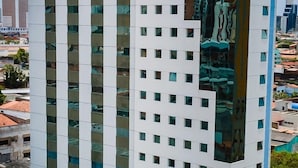 Un hotel moderno con una fachada de vidrio llamativa, varios pisos y una paleta de colores azul y blanco.
