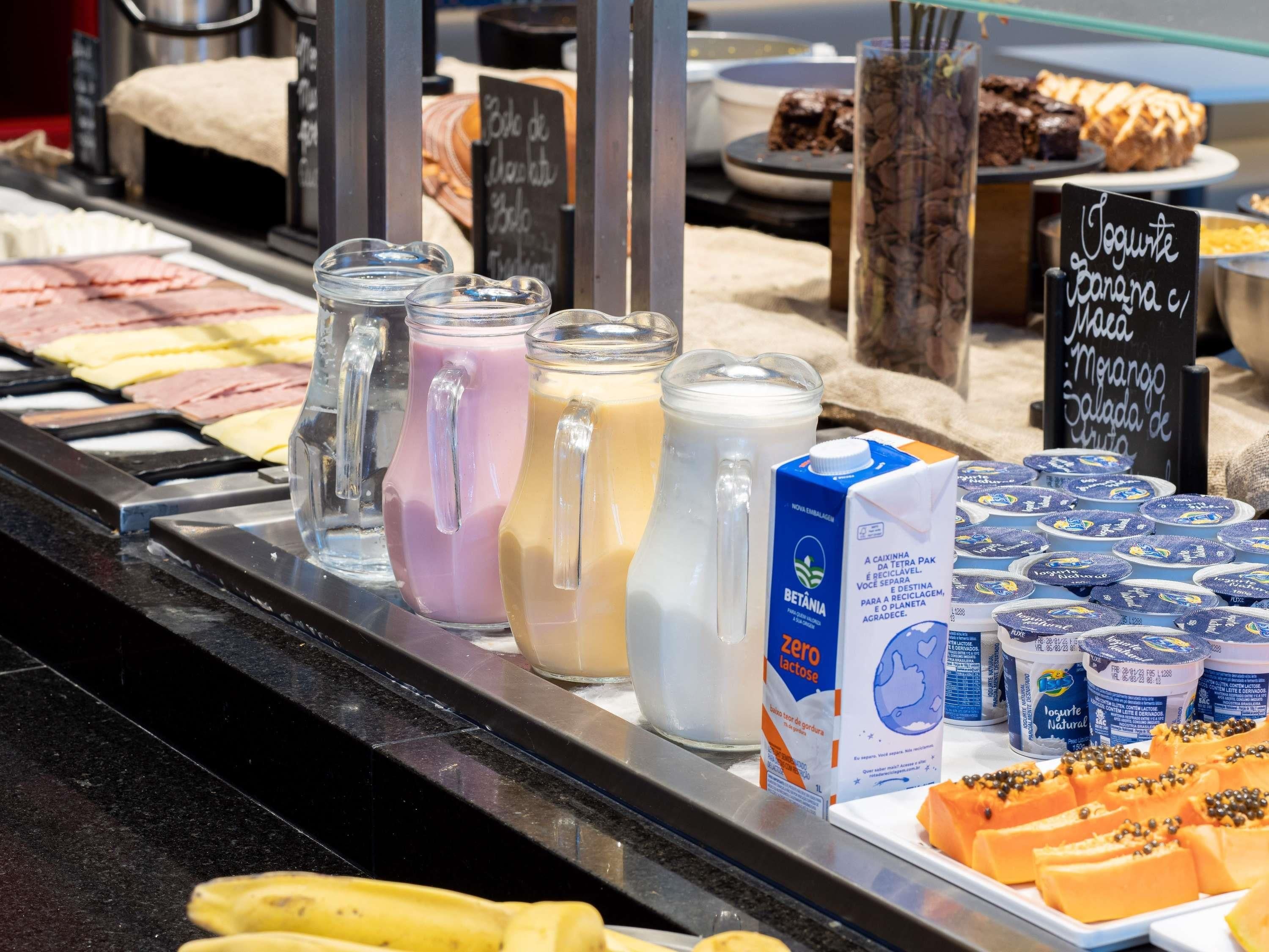 A buffet with various food options including juices, dairy products, and fruits.