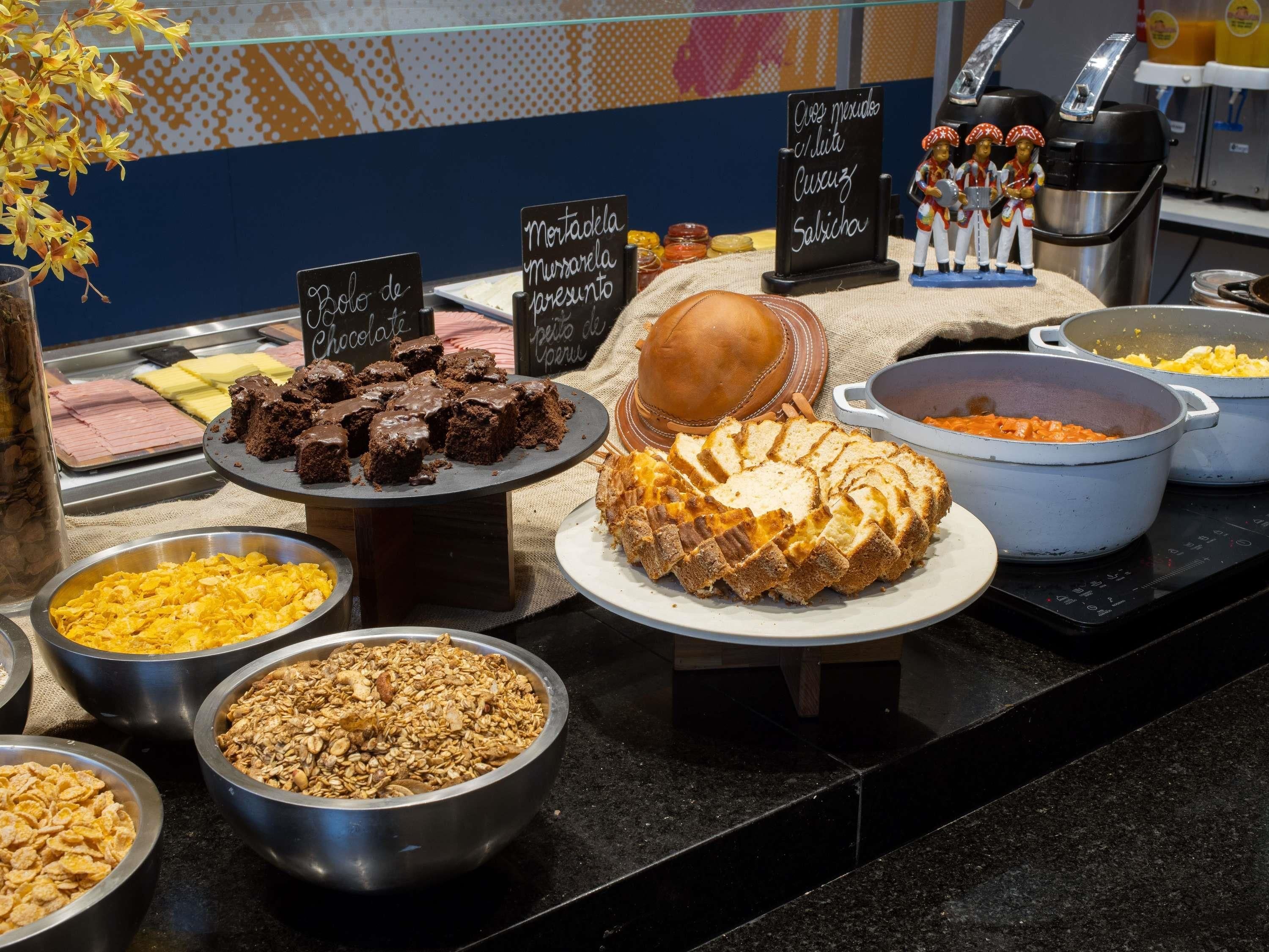 A buffet with various food items including cakes, pastries, and cereals.