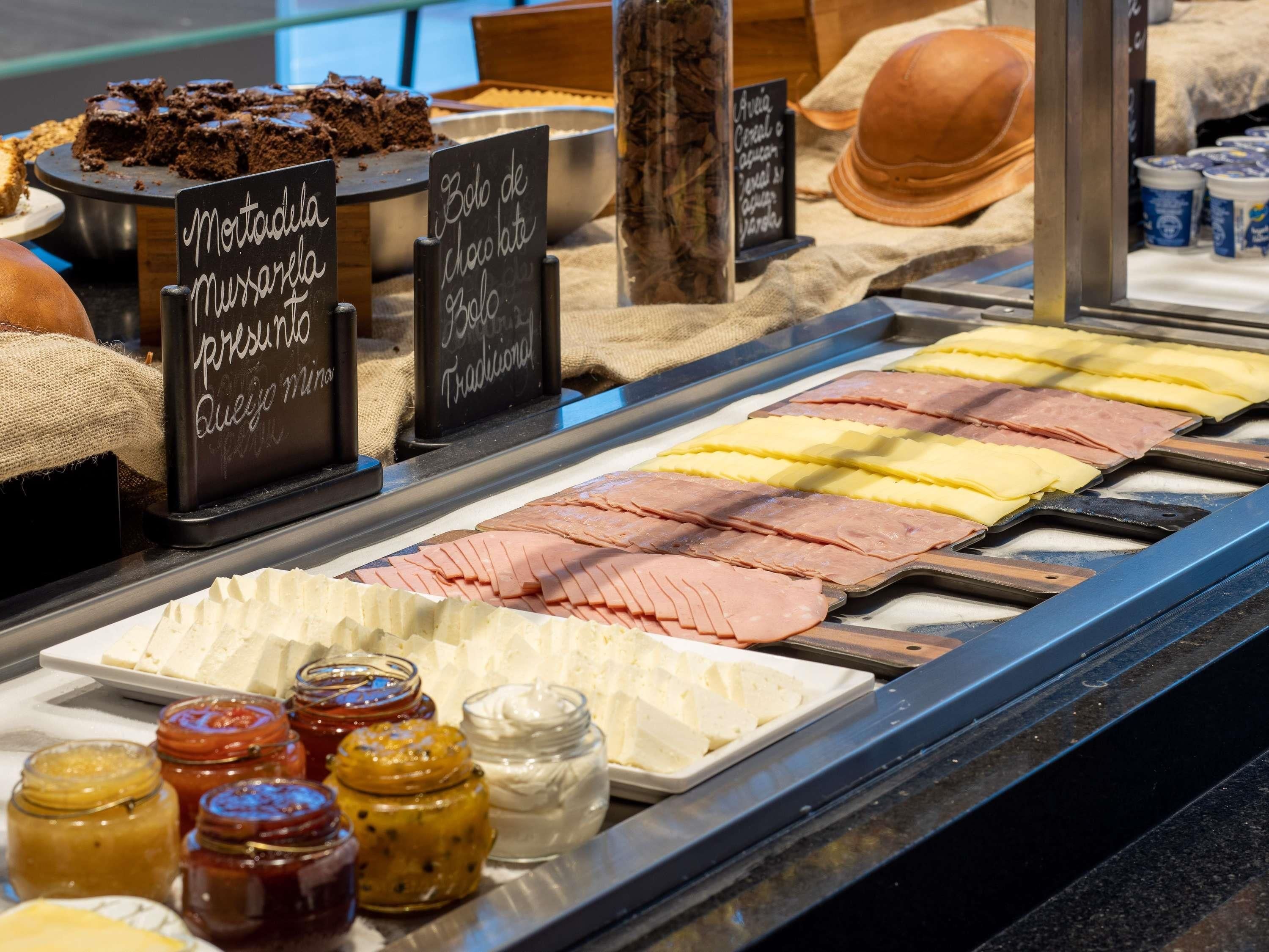 A deli counter with various meats, cheeses, and condiments.