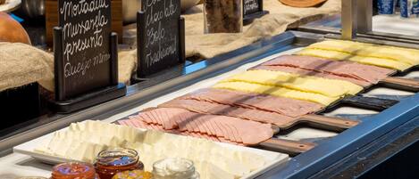 A deli counter with various meats, cheeses, and condiments.