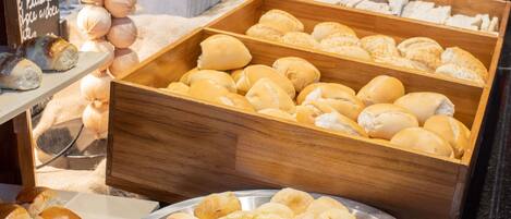A display of various baked goods including bread rolls and pastries.