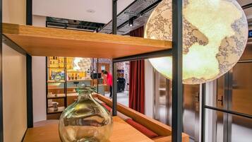Un interior moderno con una mesa de madera, un globo terráqueo y una zona de bar al fondo.