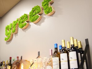 A bar area with a wooden sign spelling 'green' and various bottles of alcohol.
