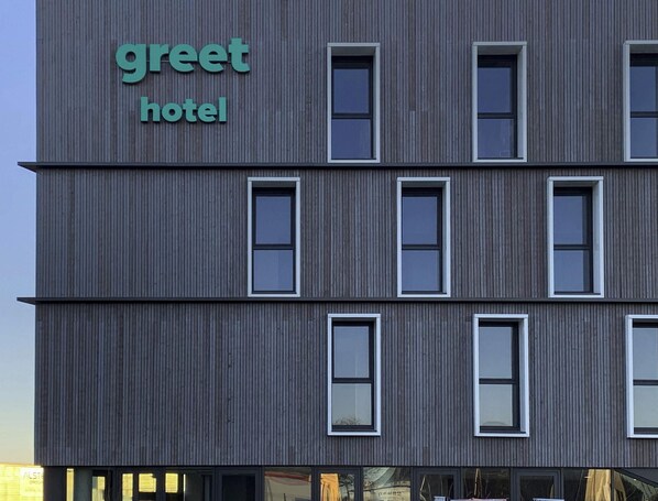 A modern building with a sign reading 'greet hotel.'