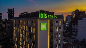 Un bâtiment portant une enseigne indiquant « ibis Styles », ce qui signifie qu’il s’agit d’un hôtel ou d’un établissement similaire.