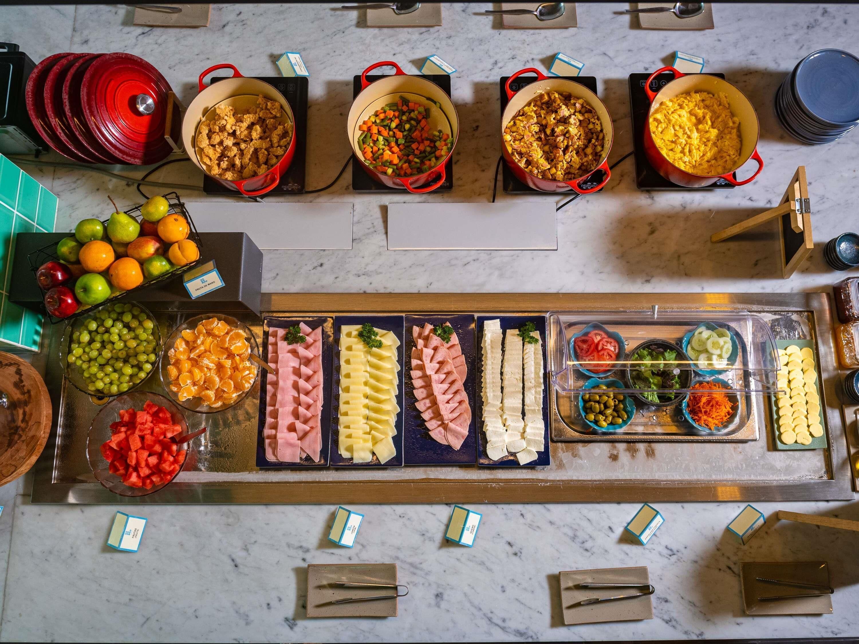 Disposição de buffet com diversos alimentos e acompanhamentos.