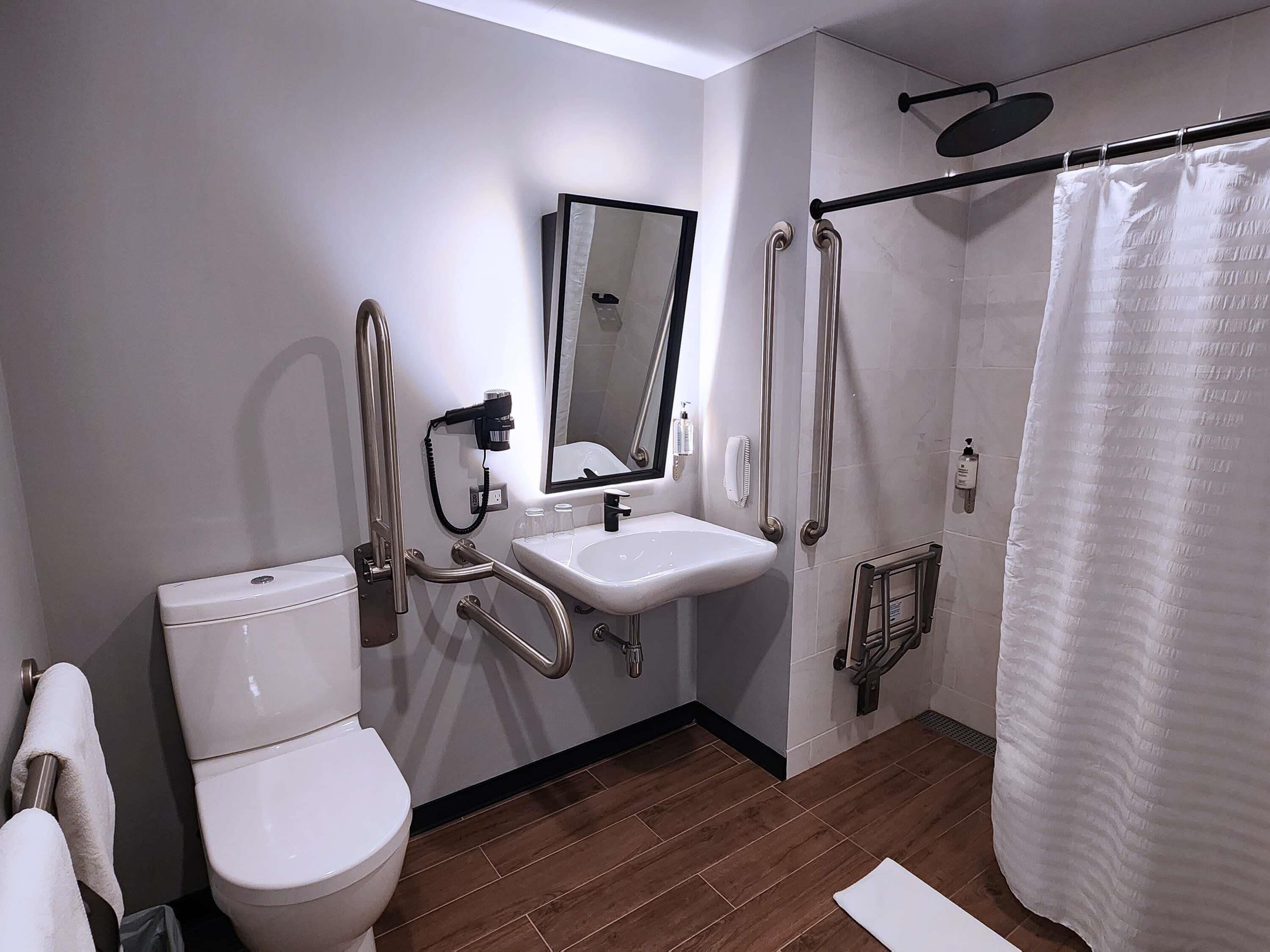 Un baño moderno con inodoro, lavamanos y ducha.