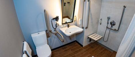 A modern bathroom with a toilet, sink, and shower.