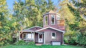 Ein modernes Haus im zweigeschossigen Stil mit überdachter Veranda und kleiner Terrasse.