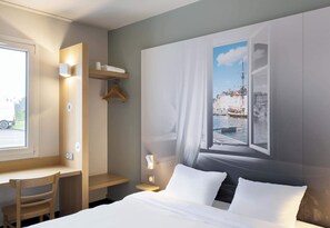 Habitación de hotel con cama, escritorio, silla, armario y una ventana grande con vista a la ciudad.