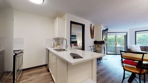 A modern kitchen with a built-in stove, a sink, and a dining area with a table and chairs.