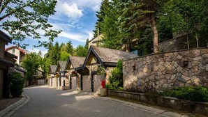 Une rue résidentielle bordée de murs en pierre et de maisons aux toits en pente.